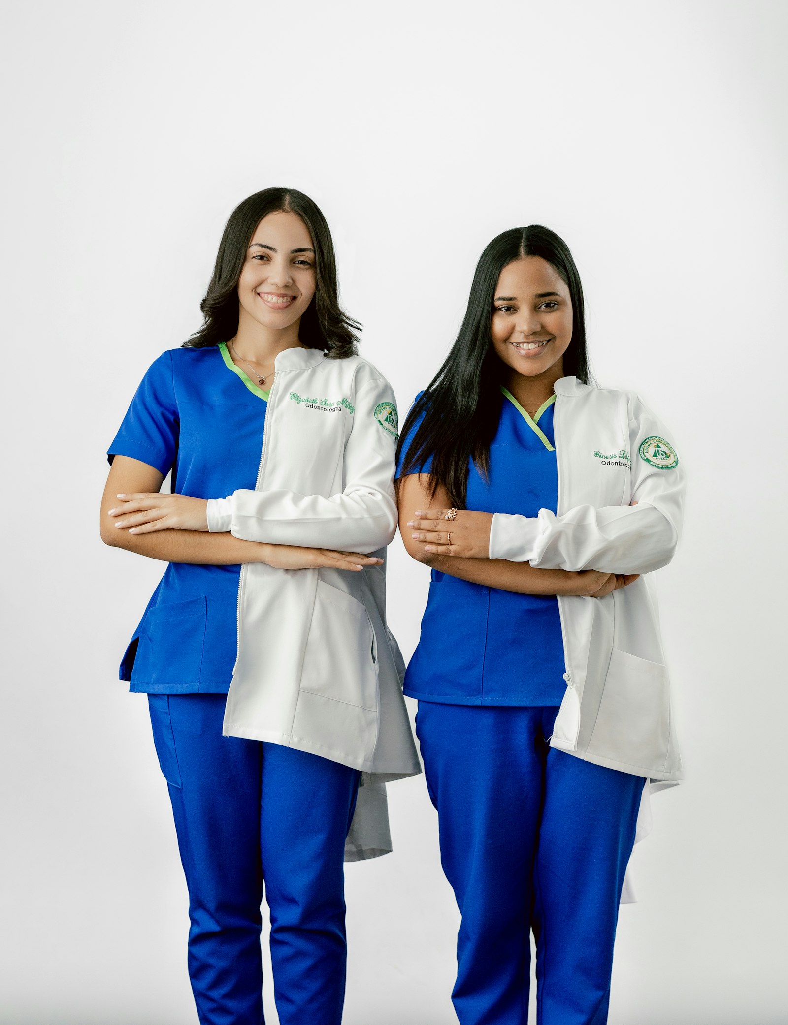 Two front desk team members in scrubs smiling