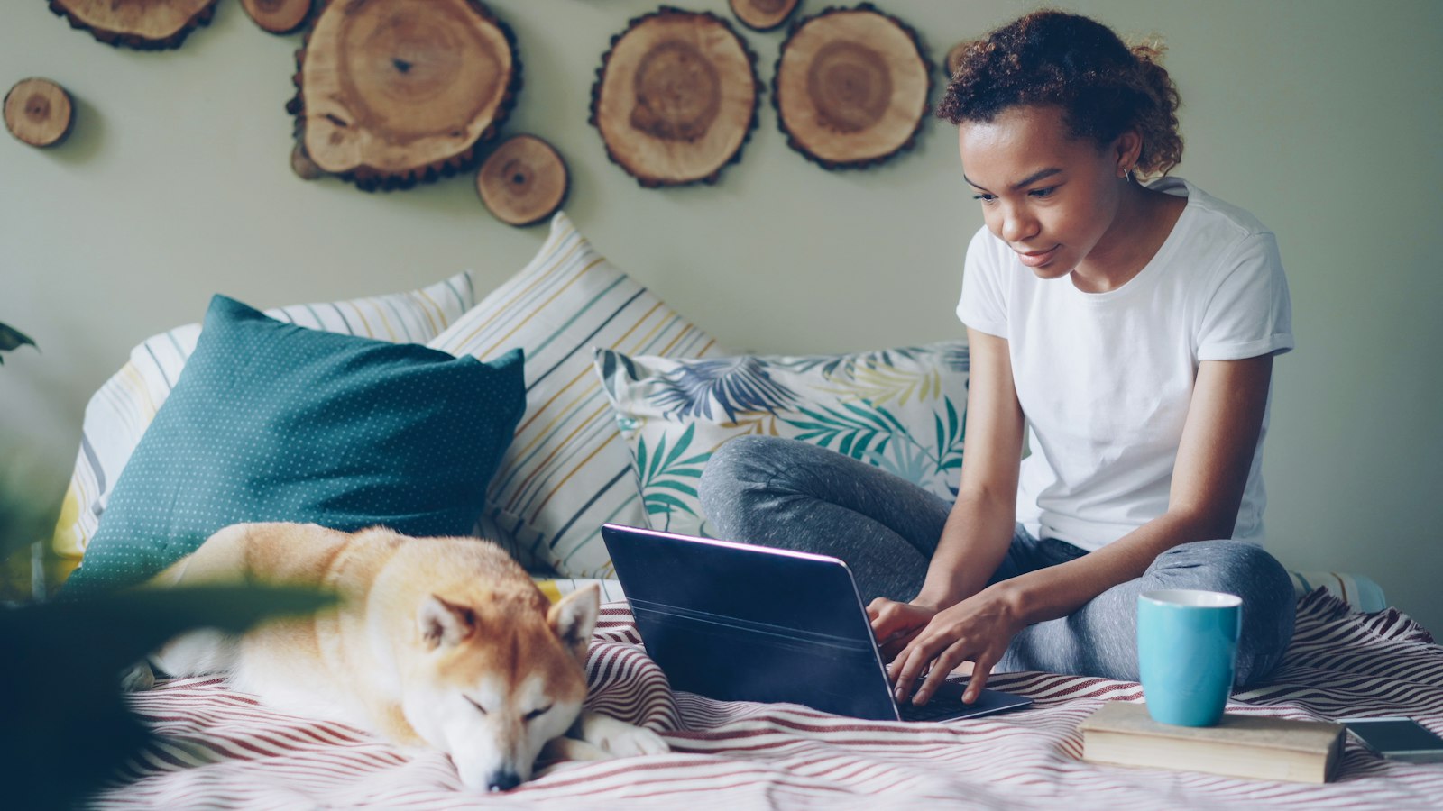 Pet owner browsing a clinic website on her laptop with her dog